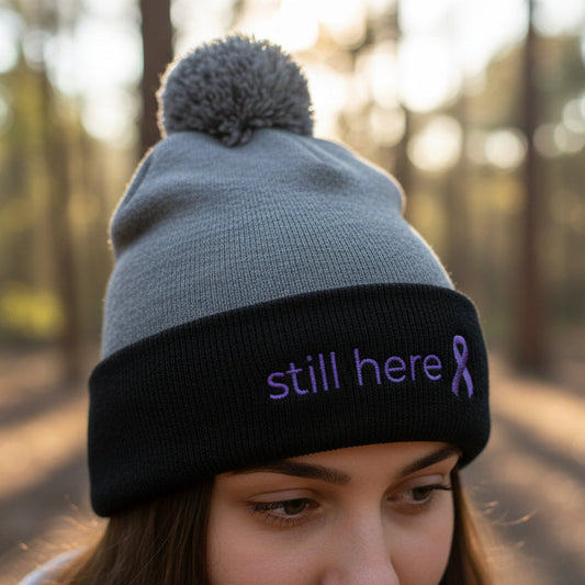 Still Here Pom-Pom Beanie – Epilepsy Awareness Knit Hat with Purple Ribbon