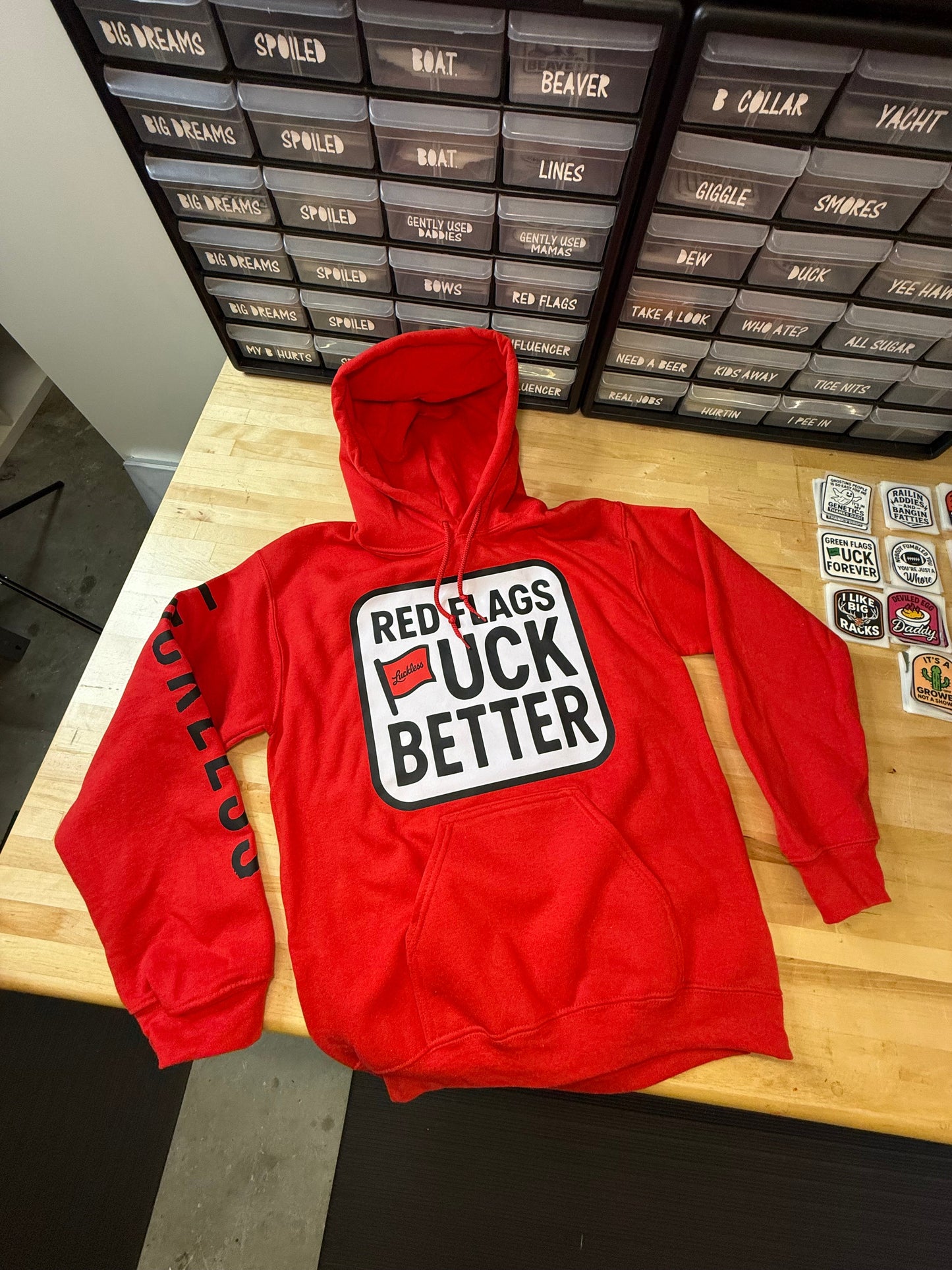 Red Flags Fuck Better Hoodie by Luckless Outfitters - Men's and Women's Funny Streetwear Pullover in Black or Bright Red with Bold Graphic Design